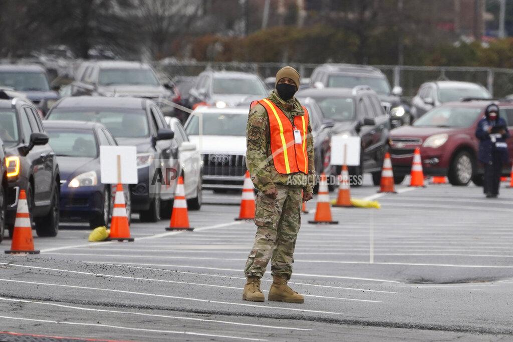 John Bazemore A member of the Georgia National guard helps manage traffic at a COVID-19 mass vaccination site at the Delta Flight Museum, Monday, Feb. 22, 2021, in Atlanta. The state has four sites located around Georgia. (AP Photo/John Bazemore)