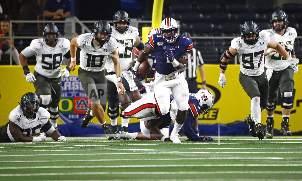 Ron Jenkins Auburn defensive end Big Kat Bryant (1) returns a fumble as Oregon quarterback Justin Herbert (10) and others pursue him during the first half of an NCAA college football game, Saturday, Aug. 31, 2019, in Arlington, Texas. (AP Photo/Ron Jenkins)