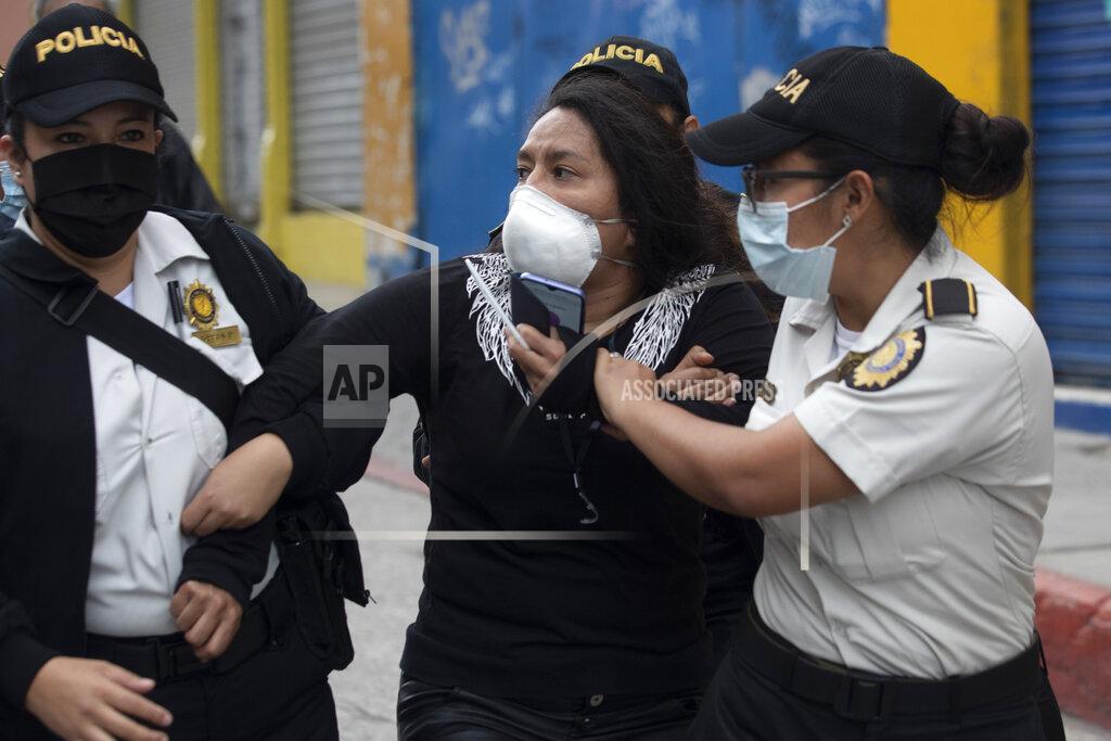 Moises Castillo A woman is detained by police near the Congress building after protesters set a part of the building on fire, in Guatemala City, Saturday, Nov. 21, 2020. Hundreds of protesters were protesting in various parts of the country Saturday against Guatemalan President Alejandro Giammattei and members of Congress for the approval of the 2021 budget that reduced funds for education, health and the fight for human rights. (AP Photo/Moises Castillo)
