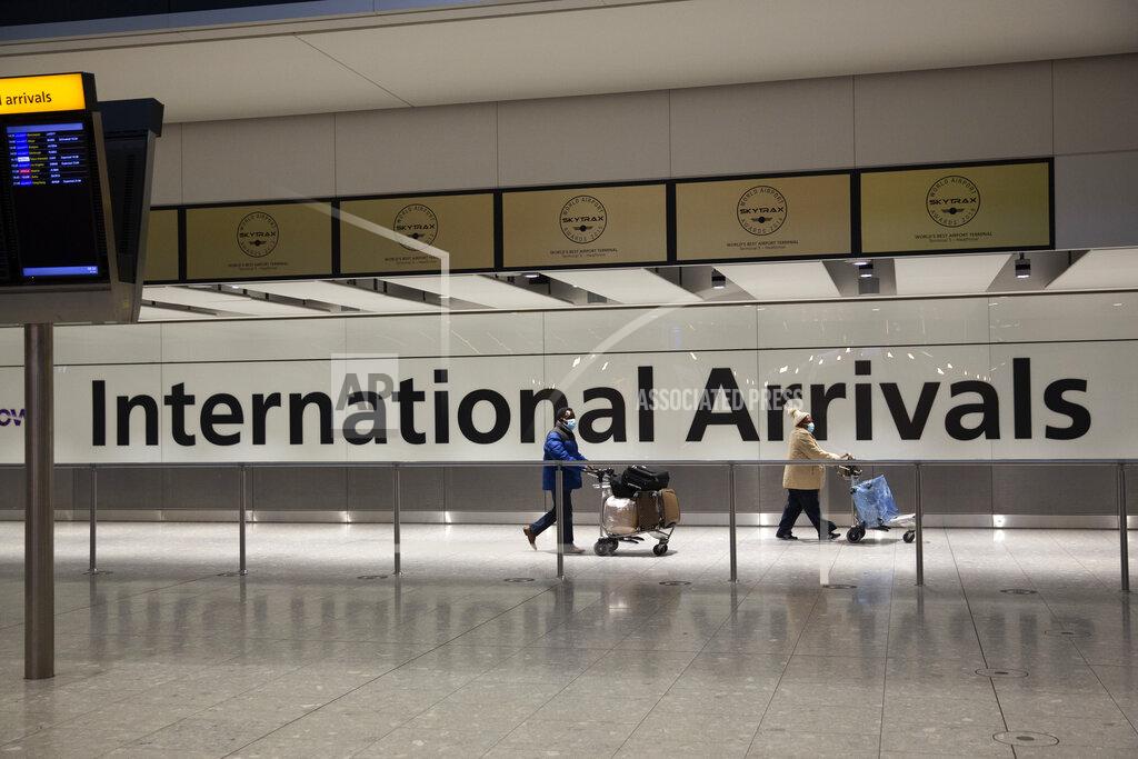 Matt Dunham FILE - In this Tuesday, Jan. 26, 2021 file photo, arriving passengers walk past a sign in the arrivals area at Heathrow Airport in London. A terminal at Heathrow Airport mothballed because of the coronavirus pandemic has reopened Tuesday, June 1 for passengers arriving from high-risk countries. Britain has barred travelers from a “red list” of 43 coronavirus hotspots including India, Brazil, Turkey and South Africa. U.K. nationals and residents who return from those countries face a mandatory 10-day supervised quarantine in a hotel.(AP Photo/Matt Dunham, File)
