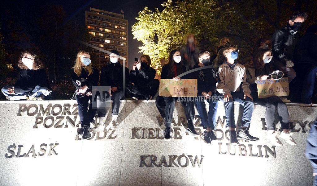 Czarek Sokolowski Protesters gather outside the parliament in Warsaw, Poland, Wednesday Oct. 28, 2020. People across Poland stayed off their jobs and huge crowds poured onto the streets for a seventh straight day of protests Wednesday, enraged over a top court ruling that bans abortions in cases of fetal abnormalities.(AP Photo/Czarek Sokolowski)