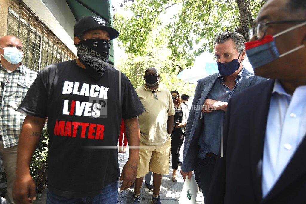 Genaro Molina Abu Hussain, left, shares his concerns with California Gov. Gavin Newsom and Los Angeles Supervisor Mark Ridley-Thomas while the governor was visiting businesses in Leimert Park in Los Angeles on Wednesday, June 3, 2020. (Genaro Molina/Los Angeles Times via AP, Pool)