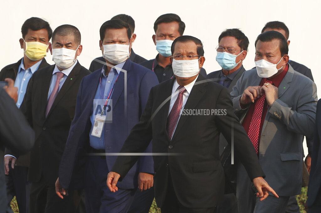 Heng Sinith Cambodian Prime Minister Hun Sen, third right, arrives for a handing over ceremony at Phnom Penh International Airport, in Phnom Penh, Cambodia, Sunday, Feb. 7, 2021. Cambodia on Sunday received its first shipment of COVID-19 vaccine, a donation of 600,000 doses from China, the country's biggest ally. Beijing has been making such donations to several Southeast Asian and African nations in what has been dubbed "vaccine diplomacy," aimed especially at poorer countries like Cambodia. (AP Photo/Heng Sinith)