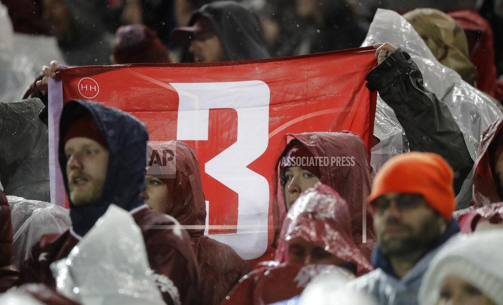 Ted S. Warren Fans hold up a #3 flag in honor of former Washington State quarterback Tyler Hilinski, who committed suicide in January of 2018, during the first half of an NCAA college football game between Washington and Washington State, Friday, Nov. 23, 2018, in Pullman, Wash. (AP Photo/Ted S. Warren)