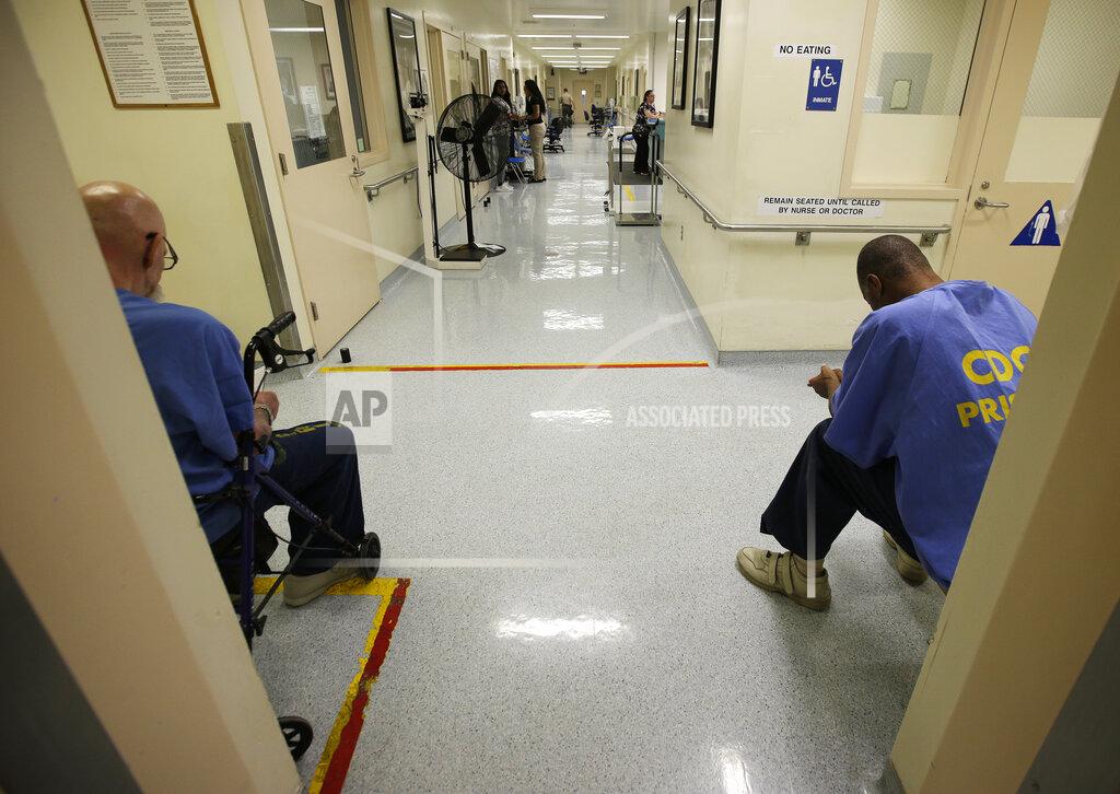 Rich Pedroncelli FILE — In this June 20, 2018, file photo, a pair of inmates wait for medical treatment at the California Medical Facility in Vacaville, Calif. Attorneys representing California inmates are urging state officials and a federal judge to advance one of every 10 prisoners to the front of the line for coronavirus vaccinations, saying it would help ease the burden on hospitals while helping control outbreaks inside state lockups. (AP Photo/Rich Pedroncelli, File)