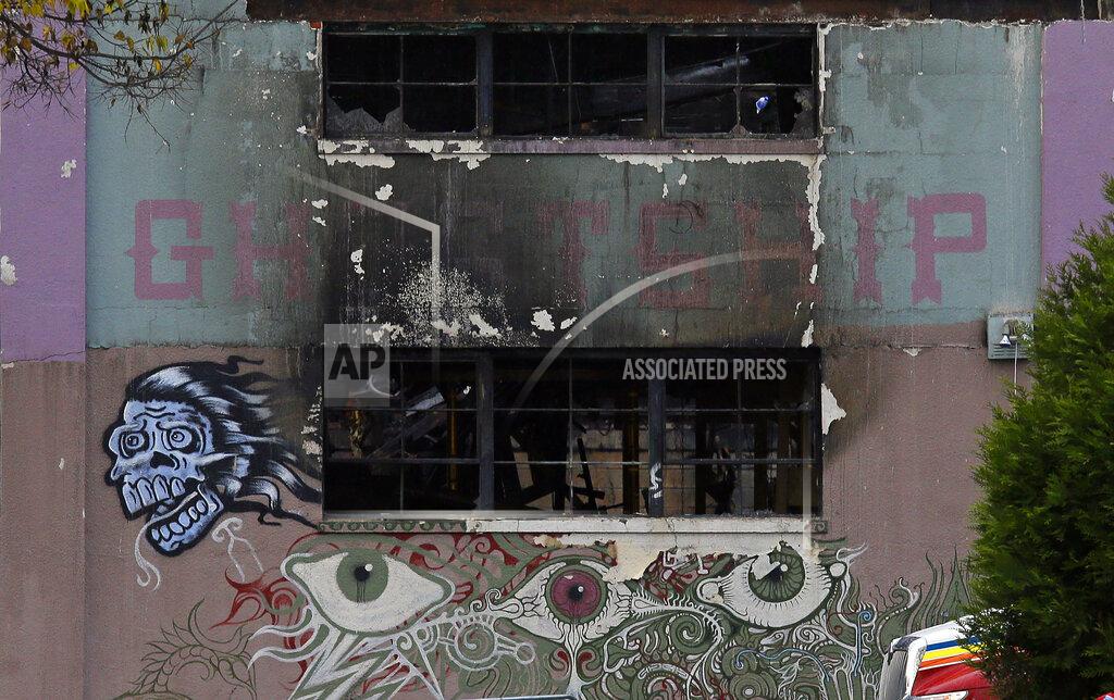 FILE - In this Dec. 7, 2016, file photo is the front of The Ghost Ship warehouse damaged from a deadly fire in Oakland, Calif. Relatives of some of the 36 partygoers killed at a San Francisco Bay Area warehouse fire say prosecutors told them Derick Almena, who is accused of illegally converting the warehouse into a cluttered artists enclave, is expected to plead guilty later this month. The victims' relatives told the East Bay Times that Almena is expected to plead guilty to 36 counts of involuntary manslaughter on Jan. 22, 2021, ahead of his second trial. (AP Photo/Eric Risberg, File)