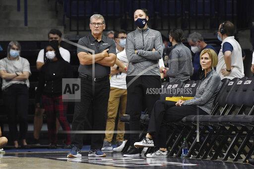 Connecticut women's coach Geno Auriemma, left, assistant coach Morgan Valley, center, and associate head coach Chris Dailey, right, watch First Night events for the UConn men's and women's NCAA college basketball teams Friday, Oct. 15, 2021, in Storrs, Conn. (AP Photo/Jessica Hill)