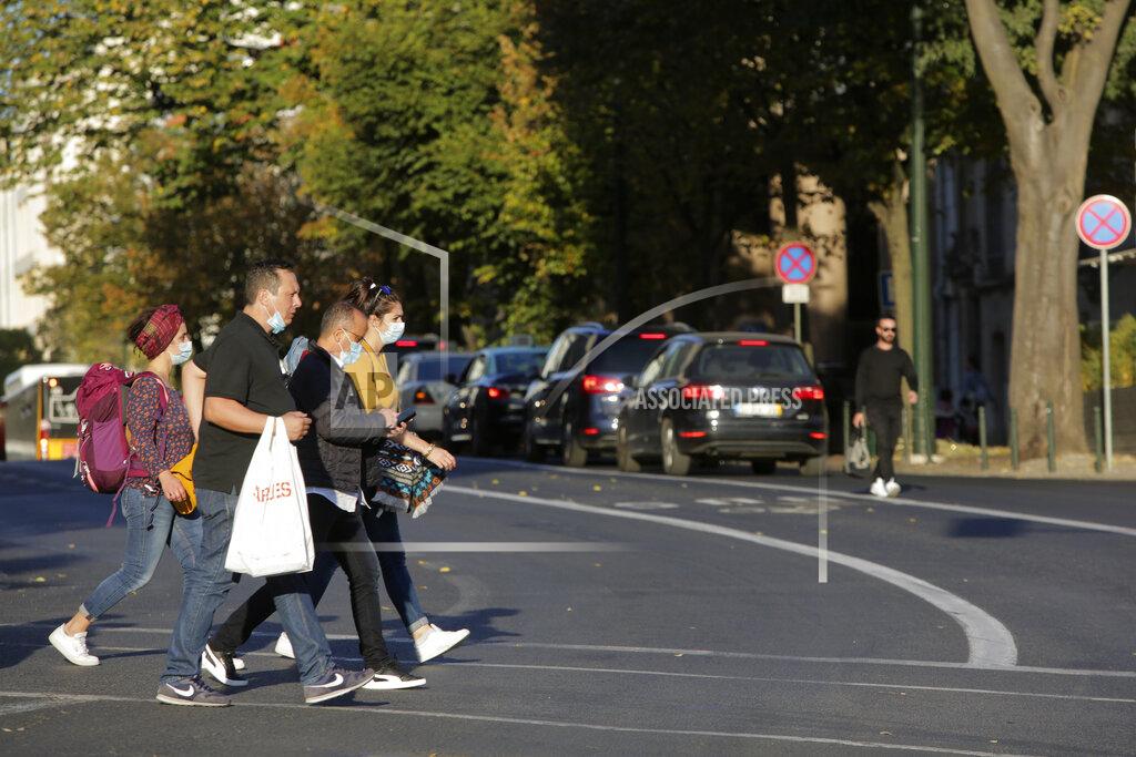 Armando Franca People wearing face masks cross a street in Lisbon, Friday, Oct. 16, 2020. Portugal has seen a steady increase in cases of COVID-19 in the past weeks. (AP Photo/Armando Franca)
