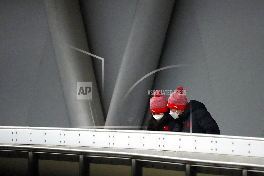 Mark Schiefelbein Chinese coaches wearing face masks to protect against COVID-19 inspect the ice during the women's race at the Luge World Cup, a test event for the 2022 Winter Olympics, at the Yanqing National Sliding Center in Beijing, Sunday, Nov. 21, 2021. (AP Photo/Mark Schiefelbein)