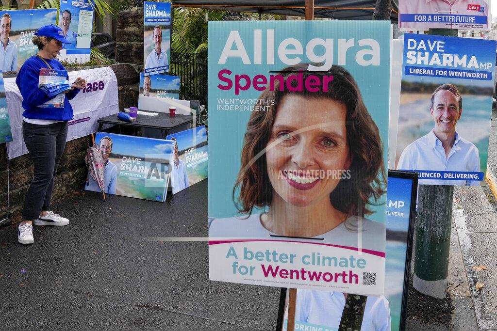 Mark Baker A volunteer stands amongst billboards for independent candidate Allegra Spender and incumbent Liberal candidate Dave Sharma outside a polling booth in Sydney, Australia on May 9, 2022. Sydney businesswoman Spender has an impeccable pedigree for a career in Australian politics. She is the daughter of a conservative federal lawmaker and granddaughter of a conservative cabinet minister. More surprising than her decision to run for office, she has chosen to become a candidate of a breakaway political grouping that has emerged as a threat to the ruling conservative Liberal Party. (AP Photo/Mark Baker)