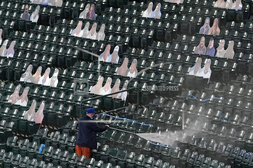 Ted S. Warren A worker pressure-washes seats at T-Mobile Park, the home of the Seattle Mariners baseball team, Monday, March 22, 2021, in Seattle as photos in the stands demonstrate how fans attending reduced-capacity games will be separated into "seating pods" to avoid the spread of COVID-19. The Mariners are scheduled to host the San Francisco Giants on April 1 in the Mariners' home-opener. (AP Photo/Ted S. Warren)