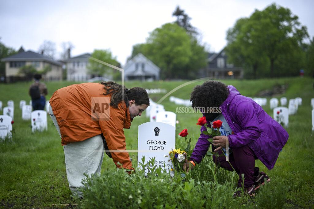 Aaron Lavinsky Maude McQuarrie, left, and Amber Martin lay flowers by George Floyd's gravestone at the 'Say Their Names' cemetery Wednesday, May 25, 2022, in Minneapolis. The intersection where Floyd died at the hands of Minneapolis police officers was renamed in his honor Wednesday, among a series of events to remember a man whose killing forced America to confront racial injustice. (Aaron Lavinsky/Star Tribune via AP)