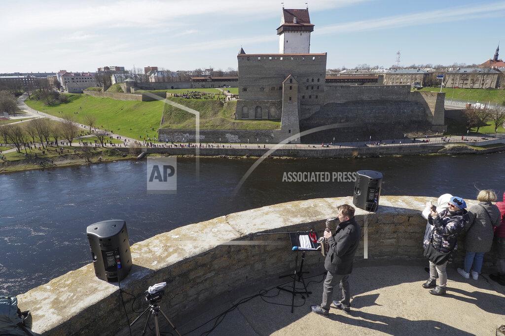 Dmitri Lovetsky Russian saxophonist Alexey Kruglov performs in the Ivangorod Fortress on the Russian-Estonian border in Ivangorod, 130 km (80 miles) west of St.Petersburg, Russia, Friday, April 30, 2021. Musicians on the Estonian-Russian border held an unusual concert on Friday, with Estonian guitarist Jaak Sooaar and Russian saxophonist Alexey Kruglov performing from the castles on the opposing banks of the Narva river that marks the border between the two countries. The concert was held on the International Jazz Day by the two musicians as an act of friendship despite the deteriorating relations between the two countries and as cross-border contacts have been limited due to the corona-virus pandemic. (AP Photo/Dmitri Lovetsky)