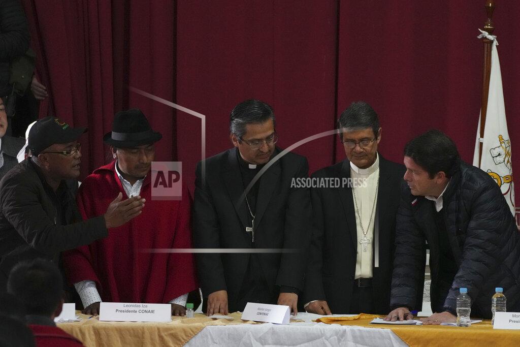 Dolores Ochoa Government representative Francisco Jimenez, right, stands on the other side of religious leaders from Indigenous leader, Gary Espinoza, far left, and Leonidas Iza, second from left, during a dialogue session mediated by the church at the Episcopal Conference headquarters in Quito, Ecuador, Thursday, June 30, 2022. The groups reached an agreement to end 18 days of often-violent strikes over the price of gas that had virtually paralyzed the country. Church leaders are, from left, Monsignors David de la Torre and Luis Cabrera. (AP Photo/Dolores Ochoa)
