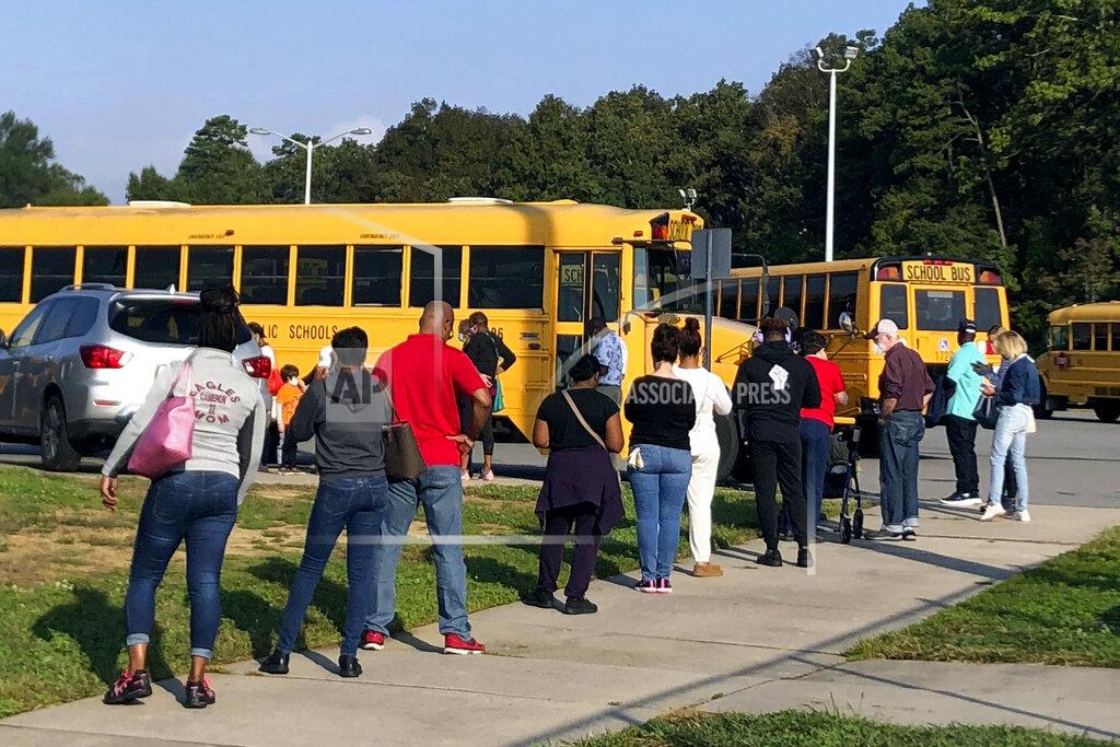 Laurie Kellman In this Thursday, Oct. 15, 2020, photo voters line up at Mallard Creek High School during the first day of in-person voting ahead of the Nov. 3 elections in Charlotte, N.C. (AP Photo/Laurie Kellman)
