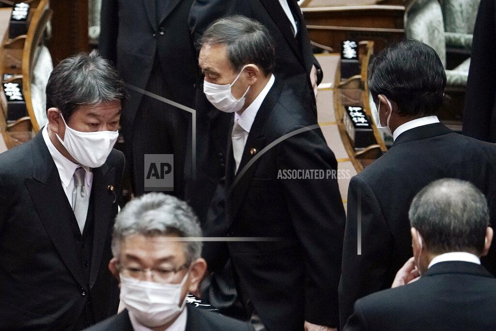 Japan's new Prime Minister Yoshihide Suga, center, walks out after attending an extraordinary session at the upper house of parliament Thursday, Sept. 17, 2020, in Tokyo. Suga started his first full day in office Thursday, with a resolve to push for reforms for the people, and he said he is already taking a crack at it. (AP Photo/Eugene Hoshiko)