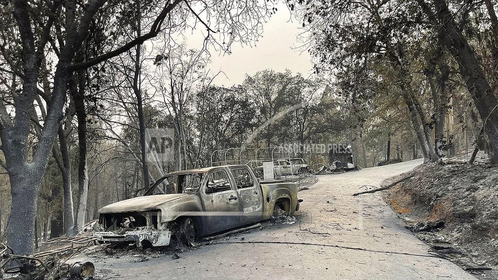 Elias Funez Charred remnants of vehicles sit in the driveway of Porfirio "Pete" Reyna's Rumford Court home in Chicago Park where everything, including his home were a total loss due to the River Fire. Reyna, like others have already begun looking at rebuilding, Aug. 7, 2021. (Elias Funez/The Union via AP)