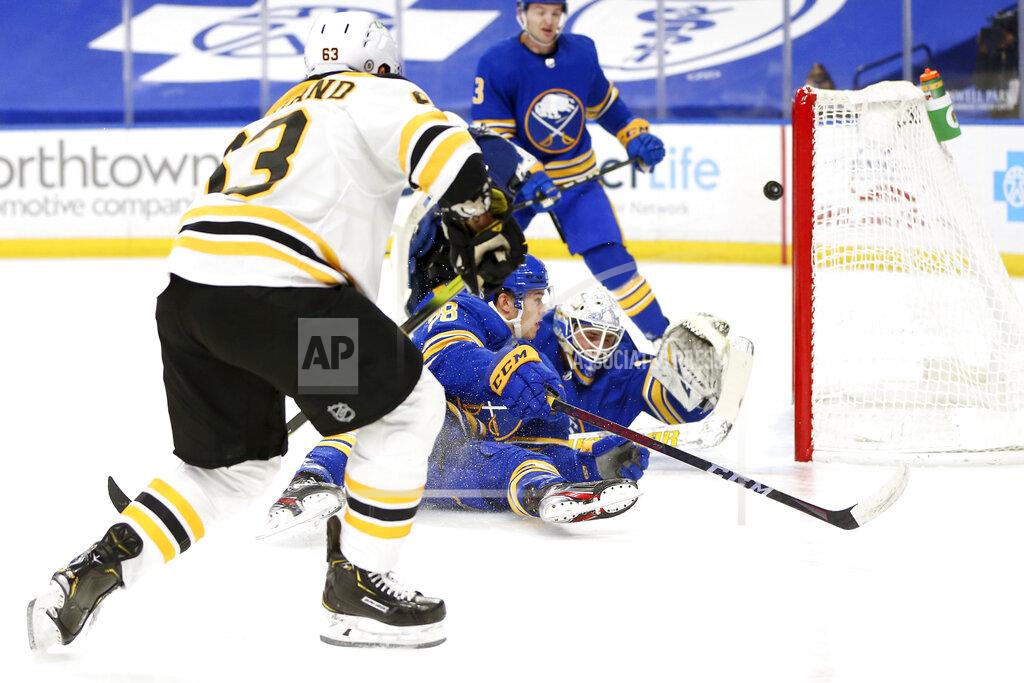 Jeffrey T. Barnes Boston Bruins forward Brad Marchand (63) puts the puck past Buffalo Sabres goalie Dustin Tokarski (31) during the first period of an NHL hockey game, Thursday, April 22, 2021, in Buffalo, N.Y. (AP Photo/Jeffrey T. Barnes)