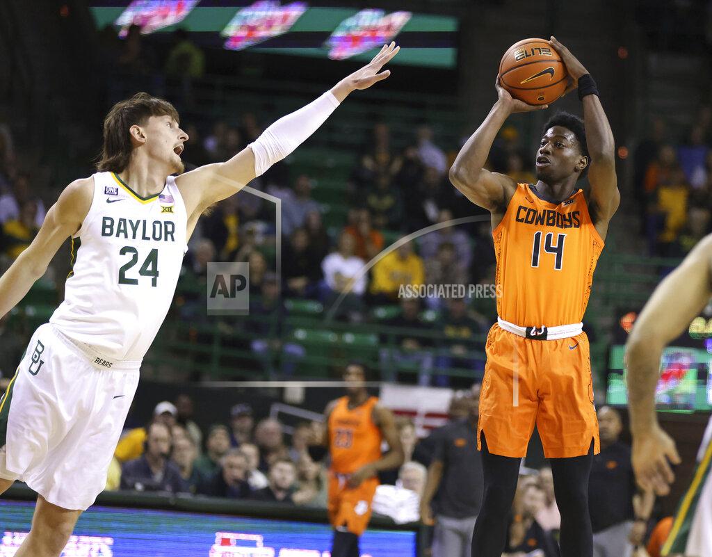 Rod Aydelotte Oklahoma State guard Bryce Williams, right, shoots over Baylor guard Matthew Mayer, left, in the first half of an NCAA college basketball game, Saturday, Jan. 15, 2022, in Waco, Texas. (Rod Aydelotte/Waco Tribune Herald, via AP)