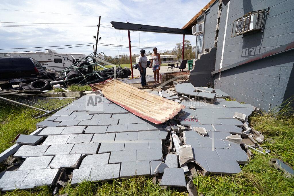 Gerald Herbert Monique Benjamin, left, and her daughter Amiah Winbush, 17, look at the damage to their car detailing business, in Lake Charles, La., in the aftermath of Hurricane Laura, Sunday, Aug. 30, 2020. (AP Photo/Gerald Herbert)