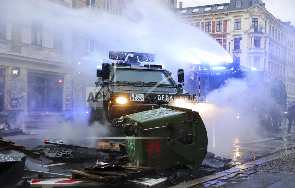 Jan Woitas A water cannon and an evacuation tank clear a barricade on Wolfgang-Heinze-Strasse after riots broke out at the end of a left-wing demonstration, in Leipzig, Germany, Saturday, Sept. 18, 2021. The campaign alliance "We are all Linx" had mobilized nationwide for the demonstration. (Jan Woitas/dpa via AP)