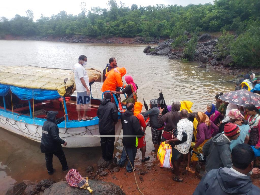 Uncredited This photograph provided by India's National Disaster Response Force (NDRF) shows NDRF personnel rescuing stranded people in Satara, in the western Indian state of Maharashtra, Friday, July 23, 2021. Landslides triggered by heavy monsoon rains hit parts of western India, killing more than 30 people and leading to the overnight rescue of more than 1,000 other people trapped by floodwaters, officials said Friday.(National Disaster Response Force via AP)
