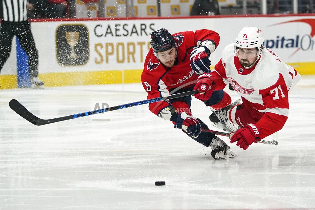 Alex Brandon Washington Capitals defenseman Dmitry Orlov (9) and Detroit Red Wings center Dylan Larkin (71) dive for the puck in the first period of an NHL hockey game, Wednesday, Oct. 27, 2021, in Washington. (AP Photo/Alex Brandon)