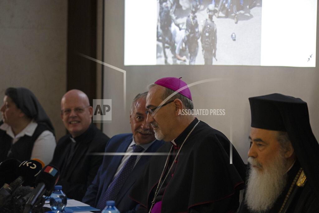 Maya Alleruzzo The Latin Patriarch of Jerusalem Pierbattista Pizzaballa, center, speaks with Jamil Koussa, General Director of St. Joseph's Hospital, beneath an image of Israeli police in riot gear during the funeral of slain Al Jazeera correspondent Shireen Abu Akleh on Friday, during a press conference about police violence against pallbearers at the funeral, in east Jerusalem, Monday, May 16, 2022. Pizzaballa, the top Catholic clergyman in the Holy Land, said Israel's police attack on mourners during a funeral for Abu Akleh was a violation of human rights and disrespected the Catholic Church. (AP Photo/ Maya Alleruzzo)