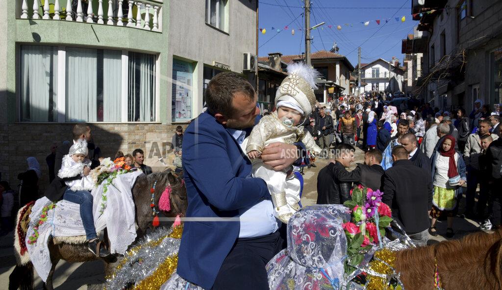 Jordan Simeonov Ismail Atipov holds his son as they take part in a mass circumcision ceremony in the village of Ribnovo, Bulgaria, Sunday, April 11, 2021. Despite the dangers associated with COVID-19 and government calls to avoid large gatherings, Hundreds of people flocked to the tiny village of Ribnovo in southwestern Bulgaria for a four-day festival of feasting, music and the ritual of circumcision which is considered by Muslims a religious duty and essential part of a man's identity. (AP Photo/Jordan Simeonov)