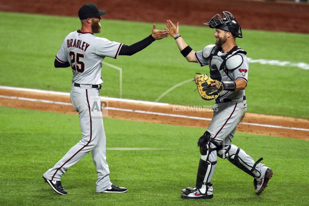Arizona Diamondbacks relief pitcher Archie Bradley, left and catcher Stephen Vogt celebrate the 4-1 win over the Texas Rangers in a baseball game Tuesday, July 28, 2020, in Arlington, Texas. (AP Photo/Richard W. Rodriguez)