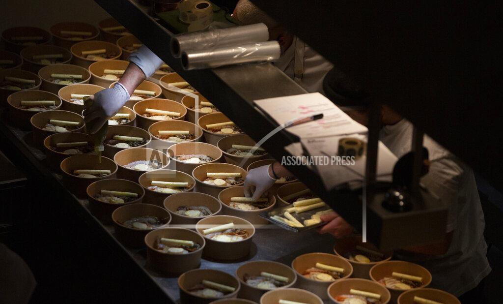 Virginia Mayo Chefs prepare a dish as they work on nearly 600 take-away orders at Sergio Herman's Le Pristine restaurant in Antwerp, Belgium, Saturday, Nov. 7, 2020. Of all the many challenges the pandemic throws up for all kinds of professions, this one has been particularly tough: How to put a three-star chef into a takeout box. (AP Photo/Virginia Mayo)