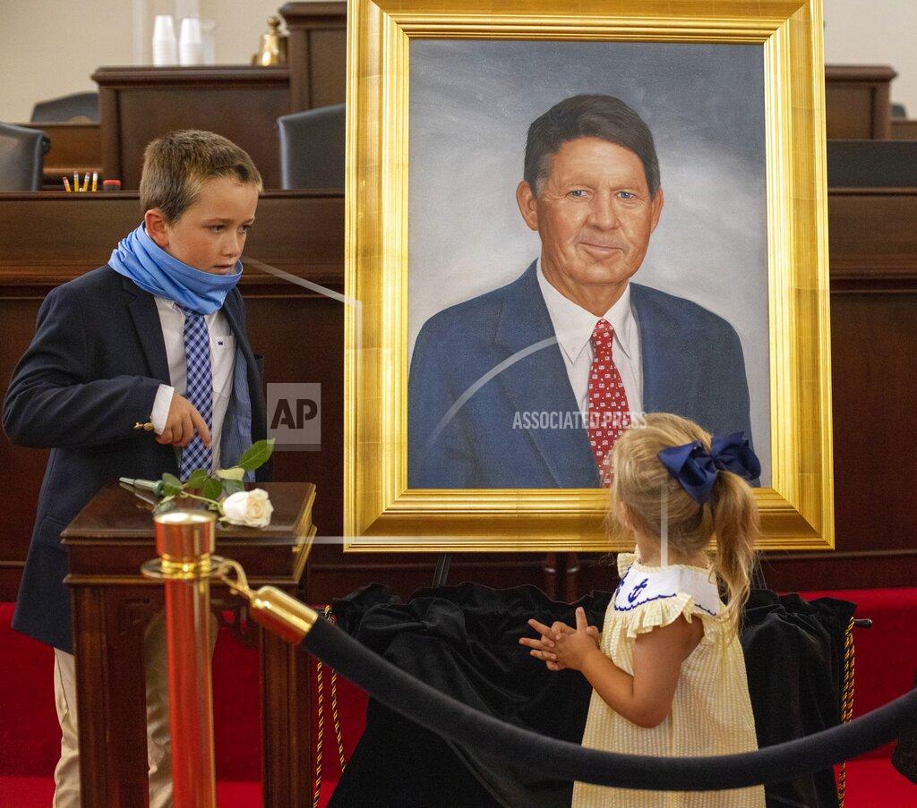 Robert Willett CORRECTS NAMES OF GRANDCHILDREN TO MARC CREW MORAN AND KENNEDY MORAN INSTEAD OF MARC CREW AND KENNEDY CREW - Marc Basnight's grandchildren Marc Crew Moran and sister Kennedy Moran look over a portrait of their grandfather former Senate President Pro Tempore Marc Basnight, after it was unveiled during a ceremony on Tuesday, Sept. 21, 2021, at the General Assembly in Raleigh, N.C. (Robert Willett/The News & Observer via AP)