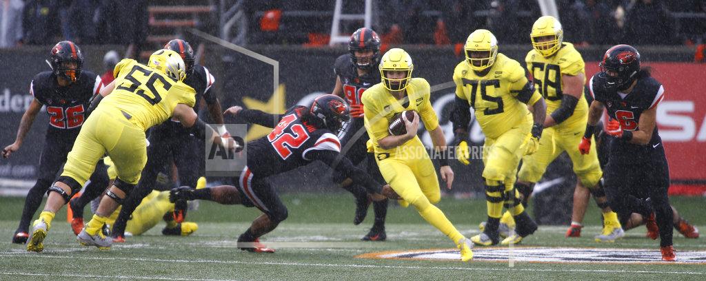 Timothy J. Gonzalez Oregon quarterback Braxton Burmeister, center right, gets past Oregon State linebacker Doug Taumoelau (42) in the second half of an NCAA college football game in Corvallis, Ore., Friday, Nov. 23, 2018. (AP Photo/Timothy J. Gonzalez)