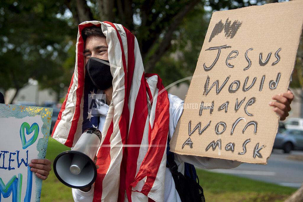 Amanda Cowan Skyview High School senior Dylan Walker, 18, shows his support for masks in school during a demonstration with classmates and other protesters in Vancouver, Wash., on Tuesday, Sept. 7, 2021. A Clark County Superior Court judge granted an injunction Tuesday prohibiting protests, rallies or other demonstrations that “disrupt educational services” within one mile of Vancouver schools. The decision followed a lockdown at three schools Friday after some anti-mask protesters tried to enter Skyview High School.(Amanda Cowan/The Columbian via AP)