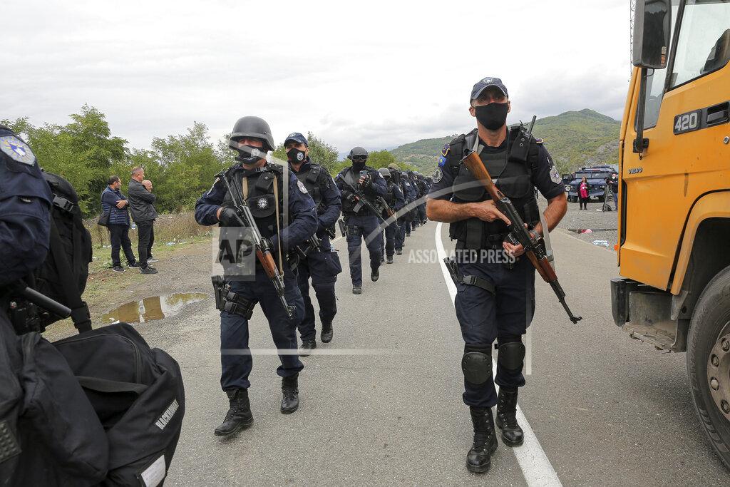 Visar Kryeziu Kosovo police officers walk to replace their colleagues near the northern Kosovo border crossing of Jarinje on Tuesday, Sept. 21, 2021. Tensions soared Monday when Kosovo special police with armored vehicles were sent to the border to impose a rule on temporarily replacing Serb license plates from cars while they drive in Kosovo. (AP Photo/Visar Kryeziu)