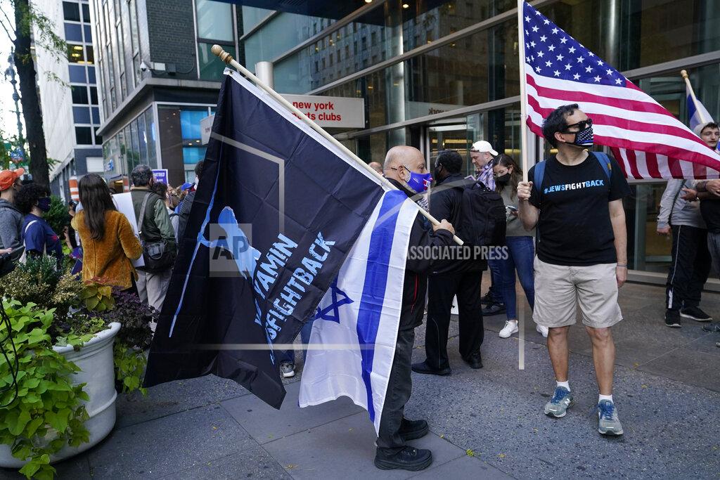 A man holds a Yad Yamin #Fightback flag along with an Israeli flag as he stands next to another man with an American flag as they joined protesters outside the offices of New York Gov. Andrew Cuomo, Thursday, Oct. 15, 2020, in New York. Three Rockland County Jewish congregations filed a lawsuit Wednesday accusing Gov. Andrew Cuomo of engaging in a streak of anti-Semitic discrimination with a crackdown on religious gatherings. The Manhattan federal court lawsuit says Cuomo has made numerous discriminatory statements about the Jewish Orthodox community. (AP Photo/Kathy Willens)
