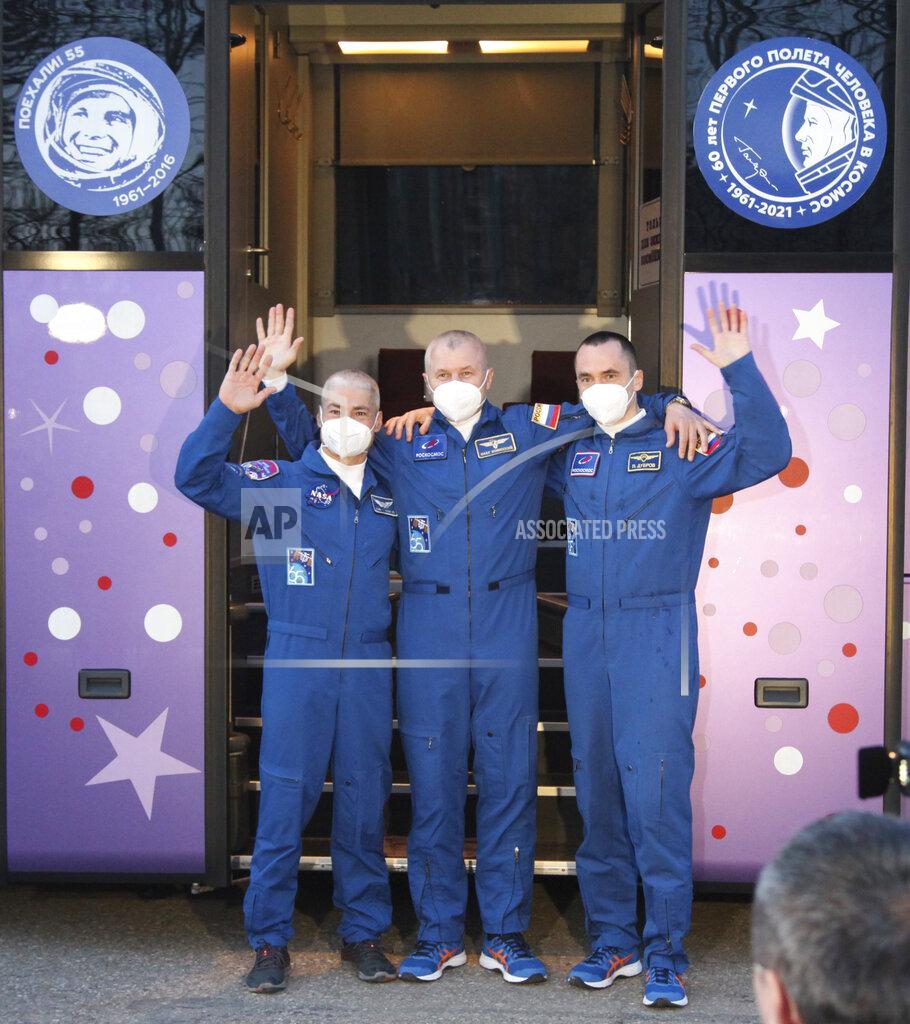 Uncredited In this photo released by the Roscosmos Space Agency, from left, U.S. astronaut Mark Vande Hei, Russian cosmonauts Oleg Novitsky and Pyotr Dubrov, members of the main crew to the International Space Station (ISS), waves near a bus with portraits of the first cosmonaut Yuri Gagarin prior to the launch at the Russian leased Baikonur cosmodrome, Kazakhstan, Friday, April 9, 2021. A Russian-U.S. trio of space travelers have launched successfully, heading for the International Space Station. NASA astronaut Mark Vande Hei and Russian cosmonauts Oleg Novitskiy and Pyotr Dubrov blasted off as scheduled at 12:42 p.m. (0742 GMT, 3:42 a.m. EDT) Friday aboard the Soyuz MS-18 spacecraft from the Russia-leased Baikonur launch facility in Kazakhstan. (Roscosmos Space Agency via AP)
