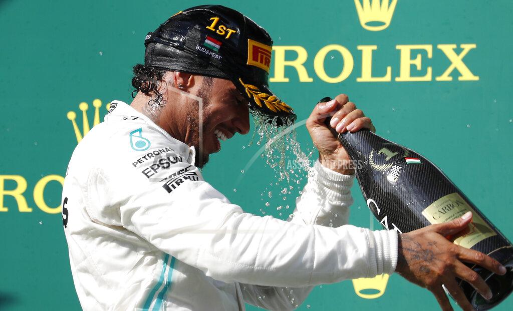 Laszlo Balogh Mercedes driver Lewis Hamilton of Britain celebrates on the podium after winning the Hungarian Formula One Grand Prix at the Hungaroring racetrack in Mogyorod, northeast of Budapest, Hungary, Sunday, Aug. 4, 2019. (AP Photo/Laszlo Balogh)
