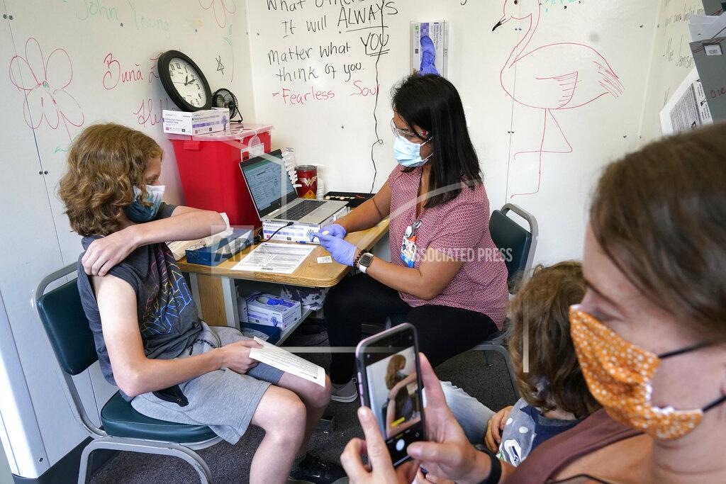 Elaine Thompson Heath F. Terry, 14, rolls up his sleeve as he gets ready to receive a COVID-19 vaccination from registered nurse Novie Kruger at PeaceHealth St. Joseph Medical Center Thursday, June 3, 2021, in Bellingham, Wash. (AP Photo/Elaine Thompson)