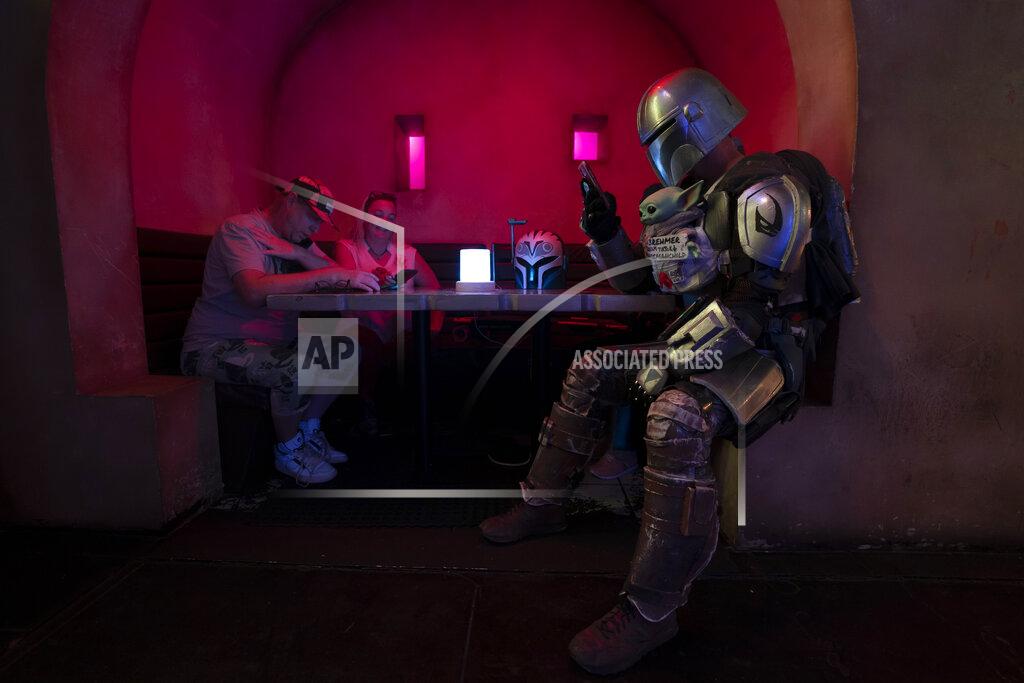 Jae C. Hong Dressed in a Star Wars costume, Tim Brehmer, right, sits in a booth as customers gather to celebrate the Star Wars Day at Scum and Villainy Cantina, a geek bar located on Hollywood Blvd, in Los Angeles, Tuesday, May 4, 2021. California has the lowest infection rate in the country. Los Angeles County, which is home to a quarter of the state's nearly 40 million people and has endured a disproportionate number of the state's 60,000 deaths, didn't record a single COVID-19 death Sunday or Monday, which was likely due to incomplete weekend reporting but still noteworthy. (AP Photo/Jae C. Hong)