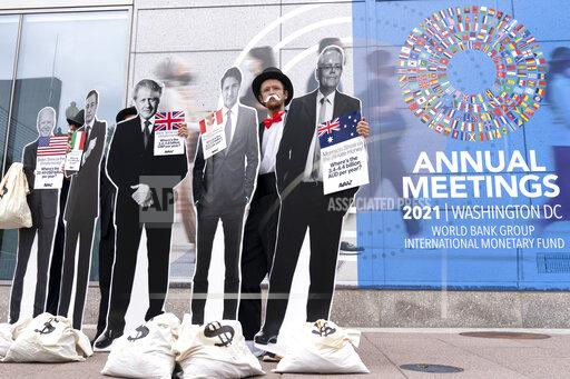 Activists holding a cardboard cutouts of President Joe Biden, Canadian Prime Minister Justin Trudeau, Australian Prime Minister Scott Morrison, Britain's Prime Minister Boris Johnson and Italian Prime Minister Mario Draghi protest outside of the International Monetary Fund headquarters during the World Bank/IMF Annual Meetings in Washington, Wednesday, Oct. 13, 2021. (AP Photo/Jose Luis Magana)
