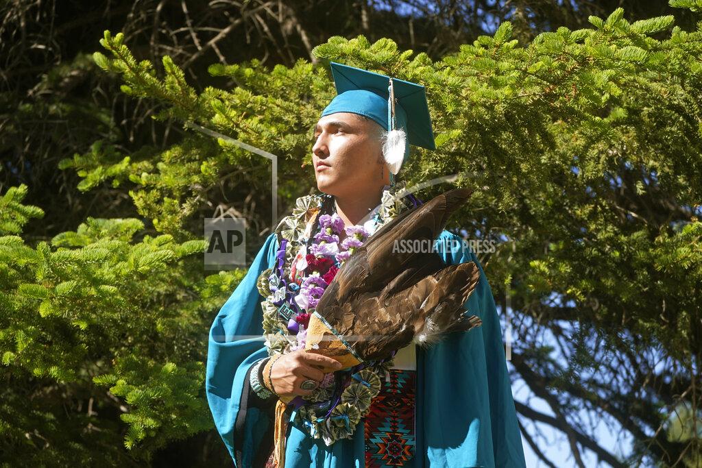 Rick Bowmer Dayne Hudson, member of the Paiute Indian Tribe of Utah, holds his eagle feather fan before the Canyon View High School graduation Wednesday, May 25, 2022, in Cedar City, Utah. Hudson said it was important to wear eagle feathers and a beaded cap to represent his family and honor those who were stopped from doing so under the old rule. (AP Photo/Rick Bowmer)