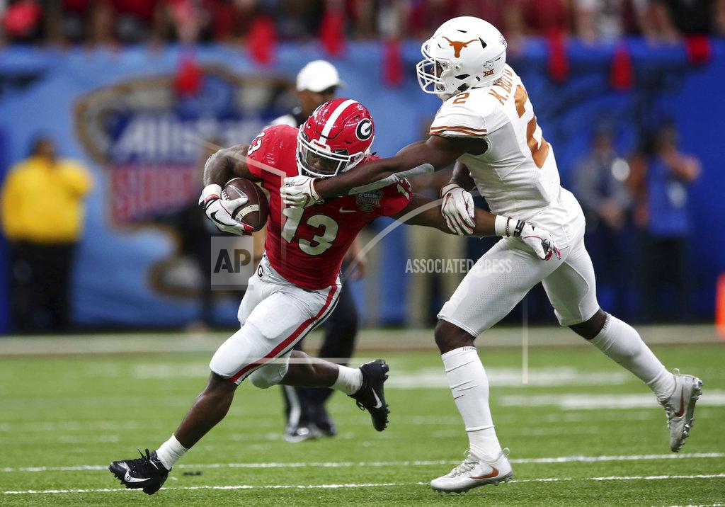 Rusty Costanza Georgia running back Elijah Holyfield (13) carries as Texas defensive back Kris Boyd (2) tries to make the tackle during the first half of the Sugar Bowl NCAA college football game in New Orleans, Tuesday, Jan. 1, 2019. (AP Photo/Rusty Costanza)