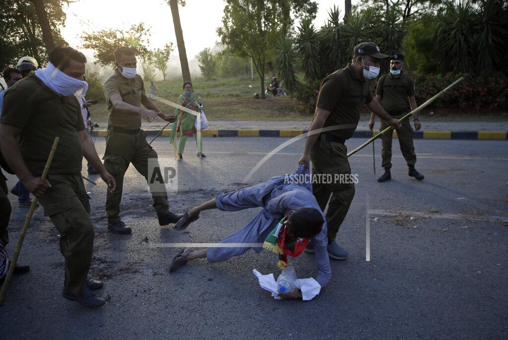 Rahmat Gul Police officers detain a supporter of Pakistan's key opposition during a protest march in Islamabad, Pakistan, Wednesday, May 25, 2022. Pakistani authorities blocked off all major roads into the capital Islamabad on Wednesday, after a defiant former Prime Minister Imran Khan said he would march with demonstrators to the city center for a rally he hopes will bring down the government and force early elections. (AP Photo/Rahmat Gul)