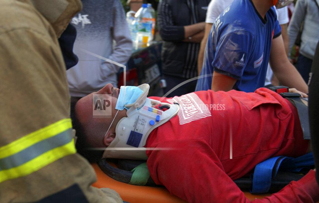 Ali Ihsan Mimtas Rescuers carry a man rescued from the debris of his collapsed house, in Izmir, Turkey, Friday Oct. 30, 2020. A strong earthquake struck Friday in the Aegean Sea between the Turkish coast and the Greek island of Samos, killing several people and injuring hundreds amid collapsed buildings and flooding. (Ali Ihsan Mimtas/Depo Photos via AP)