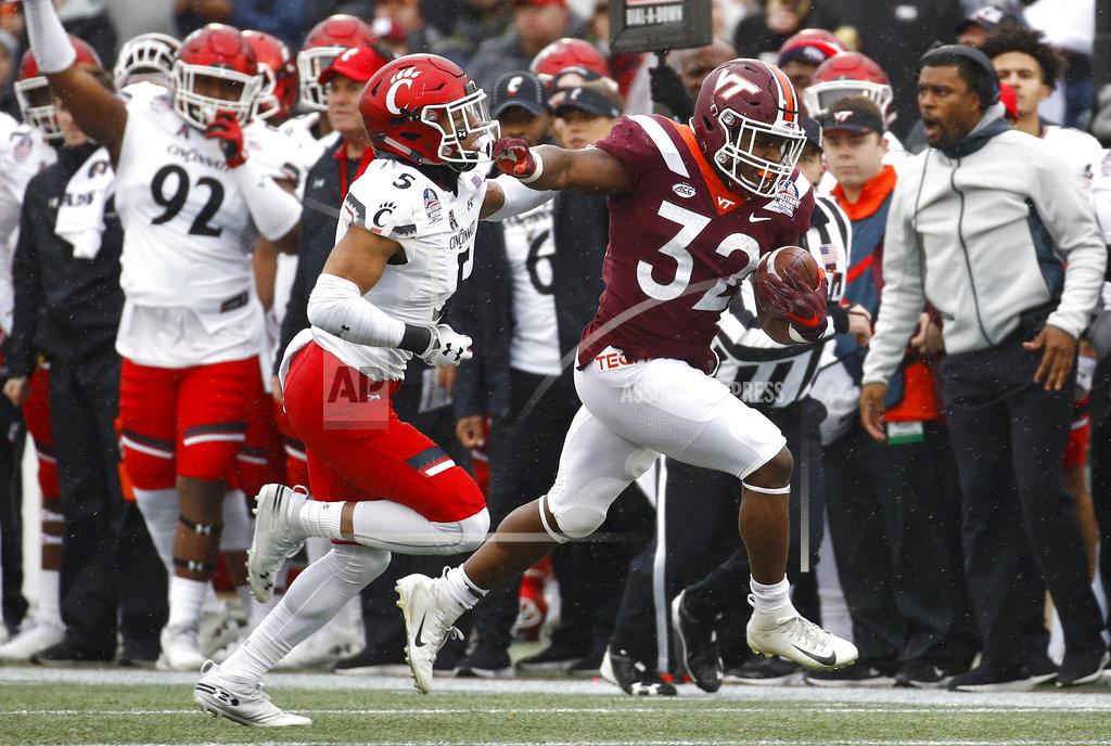 Patrick Semansky Virginia Tech running back Steven Peoples, right, rushes past Cincinnati safety Darrick Forrest in the first half of the Military Bowl NCAA college football game, Monday, Dec. 31, 2018, in Annapolis, Md. (AP Photo/Patrick Semansky)