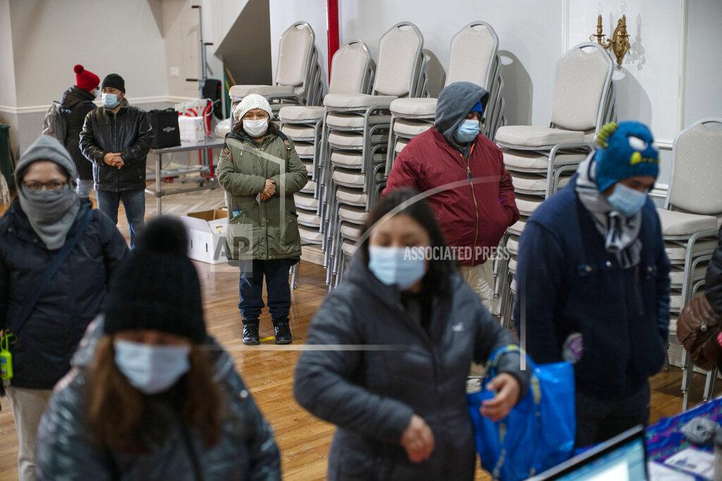 Eduardo Munoz Alvarez People wait to fill out forms at the community center Mixteca to receive food and get information about the COVID-19 vaccination during the coronavirus pandemic, Saturday, Feb. 13, 2021, in the Brooklyn borough of New York. From elderly Cuban Americans in Florida to farmworkers in California, Latinos face daunting barriers like fear, language and a lack of education and access as the COVID-19 vaccines roll out, creating risks for public health as the virus mutates and spreads. (AP Photo/Eduardo Munoz Alvarez)