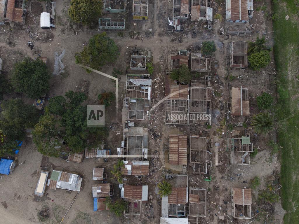 Moises Castillo The shells of homes lay in ruins in La Samaritana village after last year's hurricanes Eta and Iota destroyed the area in La Lima, on the outskirts of San Pedro Sula, Honduras, Wednesday, Jan. 13, 2021. Those who lived here are now in nearby temporary shacks made of wood and zink sheets. (AP Photo/Moises Castillo)