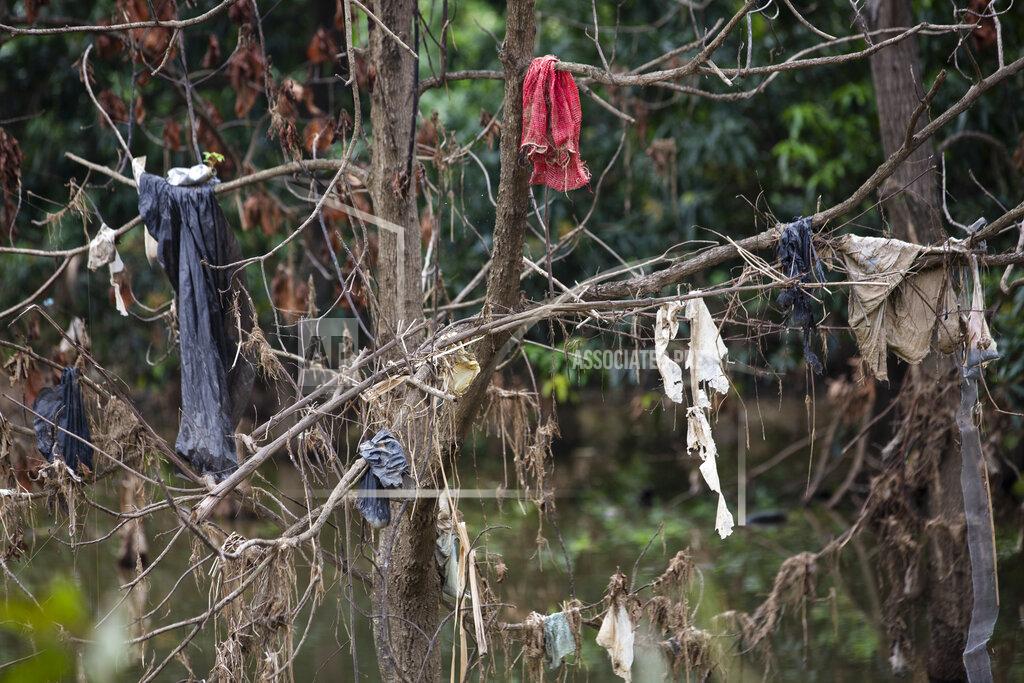 Moises Castillo Pieces of clothing hang from a tree in the Chamelecon River after the water brought by hurricanes Eta and Iota receded little by little in the Saviñon Cruz neighborhood oof San Pedro Sula, Honduras, Tuesday, Jan. 12, 2021. The assembly plants that surround San Pedro Sula and power its economy are still not back to pre-hurricane capacity amid the pandemic. (AP Photo/Moises Castillo)