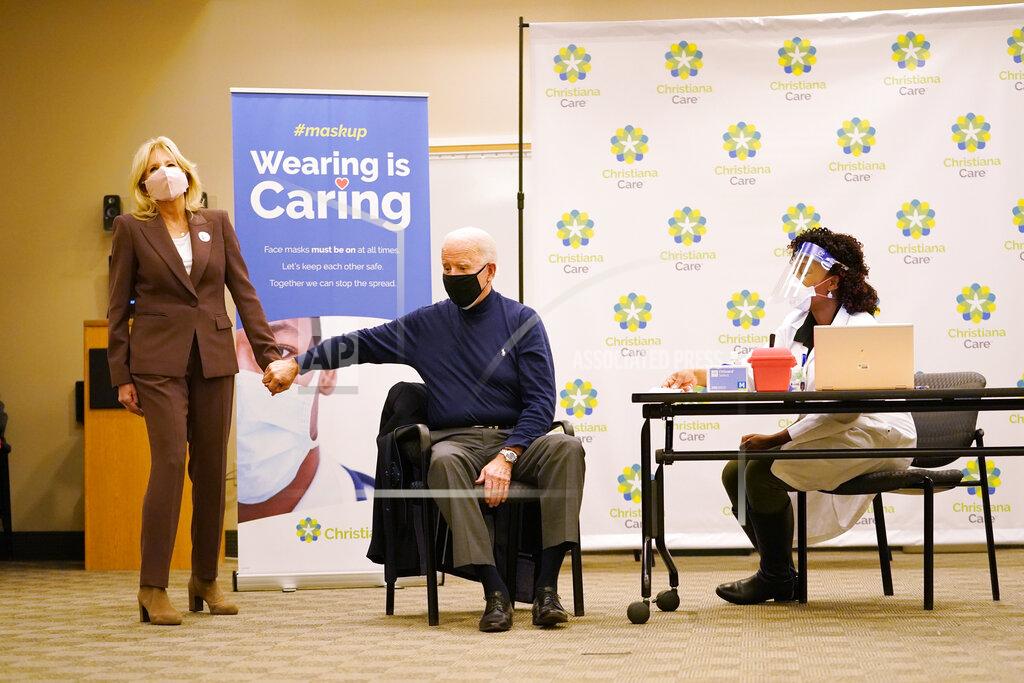 Carolyn Kaster President-elect Joe Biden received his first dose of the coronavirus vaccine at ChristianaCare Christiana Hospital in Newark, Del., Monday, Dec. 21, 2020, from nurse practitioner Tabe Mase, as Jill Biden looks on. (AP Photo/Carolyn Kaster)